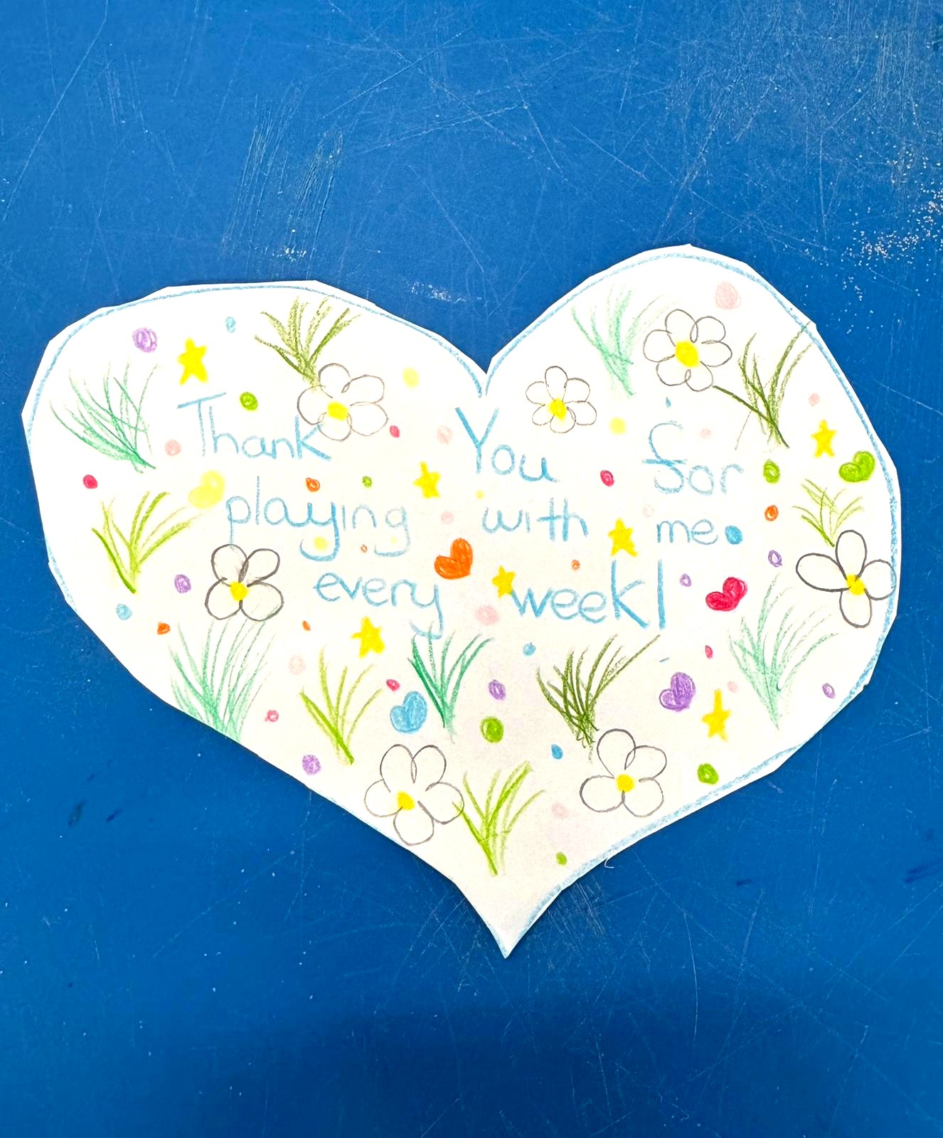 A child's handmade heart card reading: Thank you for playing with me every week